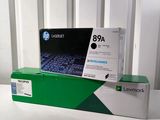 Deux cartouches de toner noires sont posées sur une table blanche