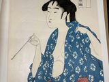 an image of a woman in a blue kimono is holding a stick