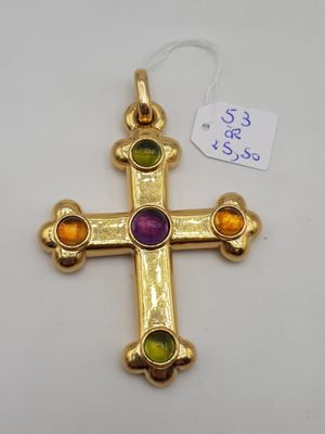 un gros plan d'une croix en or ornée de pierres multicolores