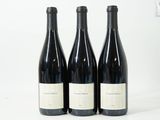trois bouteilles de vin sont alignées sur une surface blanche