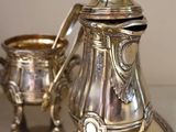 a silver plate with a silver tea pot on it