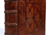 an old book with a wooden cover sitting on top of a white surface