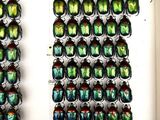 a lot of green beetles on display in a white box