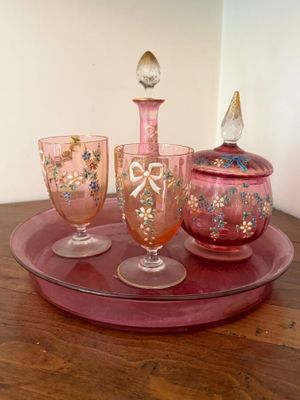three glasses and a bottle on a tray on a table