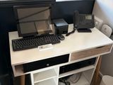a computer desk with a keyboard and a monitor on it
