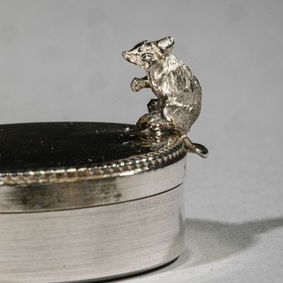 a silver box with a rat on top of it