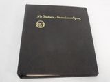 a black book with gold lettering on it sitting on a white surface