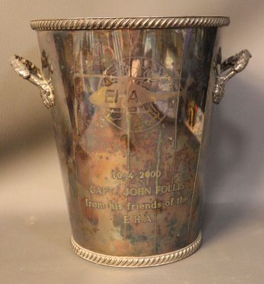 a silver vase with a picture on it on a table