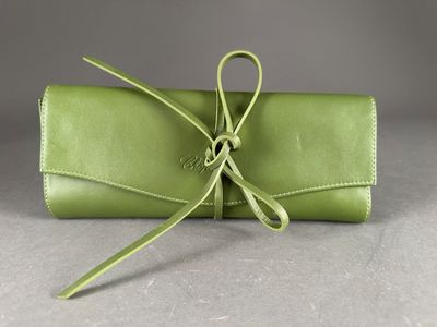 a green leather case with a ribbon tied around it