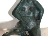 statue représentant un homme assis par terre, les jambes croisées