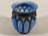 a blue glass vase with a black wire around it