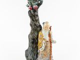 une figurine orientale représentant un homme avec un dragon sur le bras