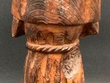 wooden statue of a man with a hat on top of his head