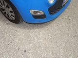 a small blue car parked in a parking lot