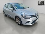 Une voiture argentée est garée dans une pièce blanche