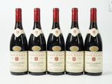 six bouteilles de vin sont alignées sur une table