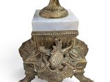 a white marble topped pedestal with a gold vase on top of it
