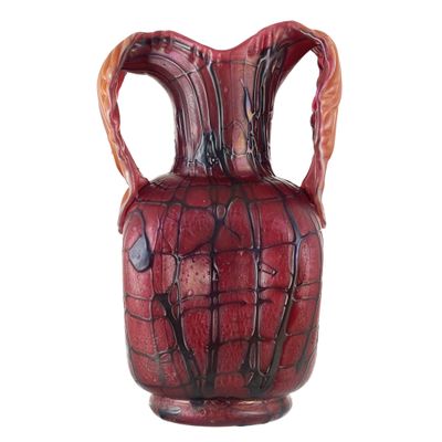 un vase rouge muni d'une anse sur fond blanc