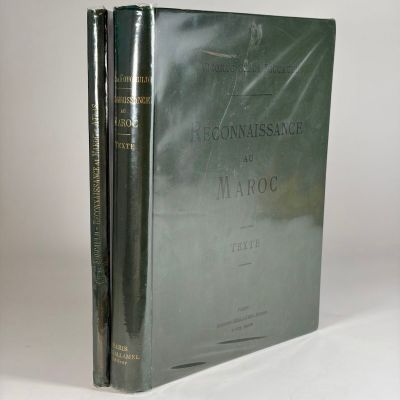 two books are stacked on top of each other on a white surface