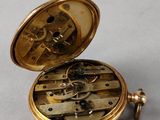 an image of a pocket watch sitting on top of a table