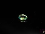 a close up of a green gemstone on a black surface
