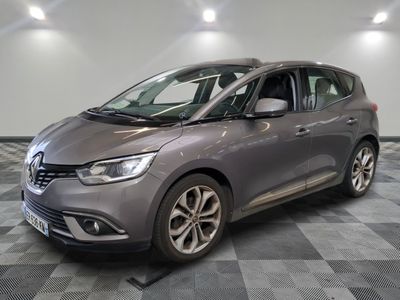 a grey car is parked on a checkered floor in a garage