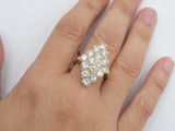 a woman ' s hand holding a gold and diamond ring