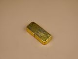 a close up of a piece of gold on a white surface