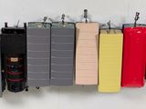 many different colors of luggage hanging on a wall