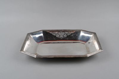 a silver plate with a design on the edge of it