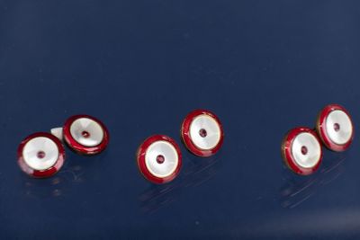 plusieurs globes oculaires rouges et blancs sont disposés en rangée sur une surface bleue