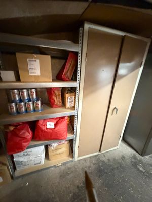 une pièce dans laquelle se trouvent quelques étagères et des cartons