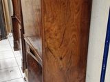 a tall wooden cabinet in the middle of a room