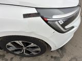 a close up of a white car parked in a parking lot