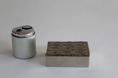 a small metal container next to a small metal container