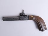 an old gun with a wooden handle on a white surface