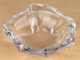 a clear glass ashtray on a wooden table