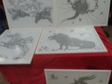 trois photos encadrées d'animaux posées sur une table recouverte d'une nappe rouge