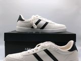 une paire de baskets blanches à rayures noires est posée sur une boîte