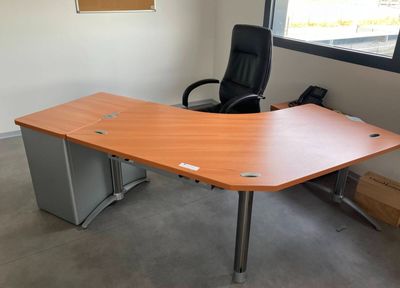 an office desk with a chair and a phone on it