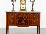 une table sur laquelle se trouvent une horloge et deux bougies