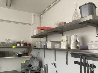 une petite cuisine avec de nombreux objets sur les étagères