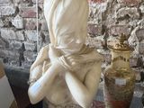 une statue représentant une femme portant un foulard sur la tête