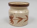 a brown and white vase with a design on it