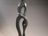 sculpture of a woman holding a child in her arms on a wooden base