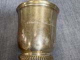 a gold cup that is sitting on a table