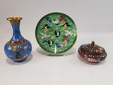 trois vases et une assiette posés sur une table