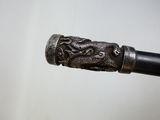 un gros plan sur une poignée en métal ornée d'un dragon