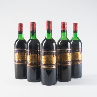 quatre bouteilles de vin sont alignées sur une surface blanche