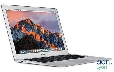 On voit un ordinateur portable MacBook Air d'Apple avec une montagne en arrière-plan.